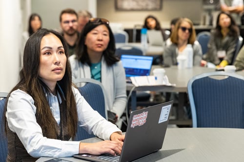 Conference attendee sitting at table with laptop open