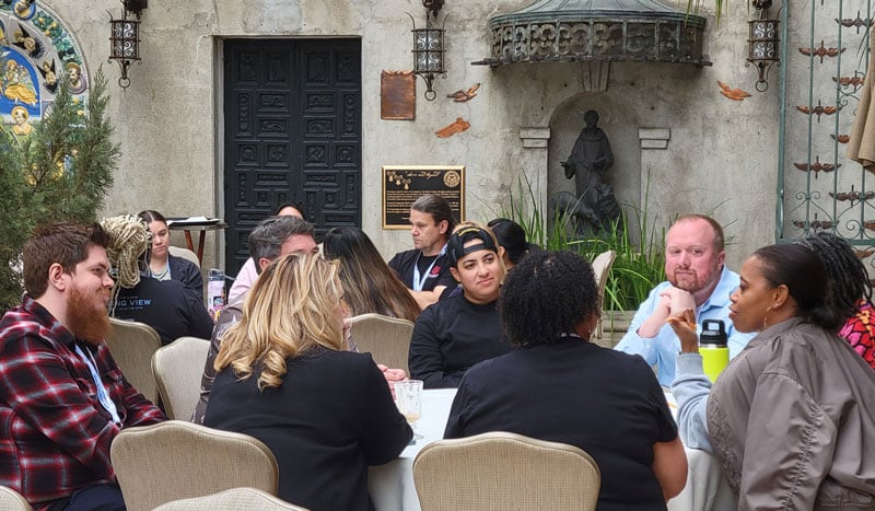 LFM participant groups in discussion at round tables.