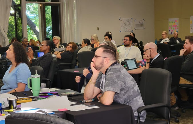 Leading from the Middle participants attentively listening to a speaker.