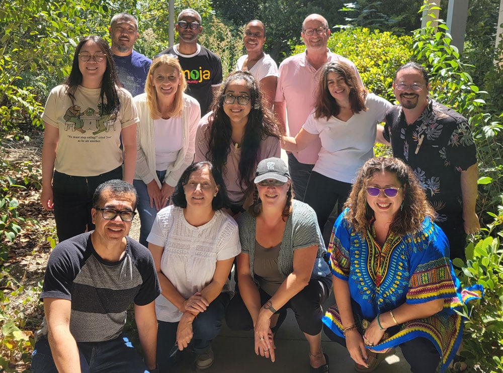 Group shot of 13 LFM team members in a garden.