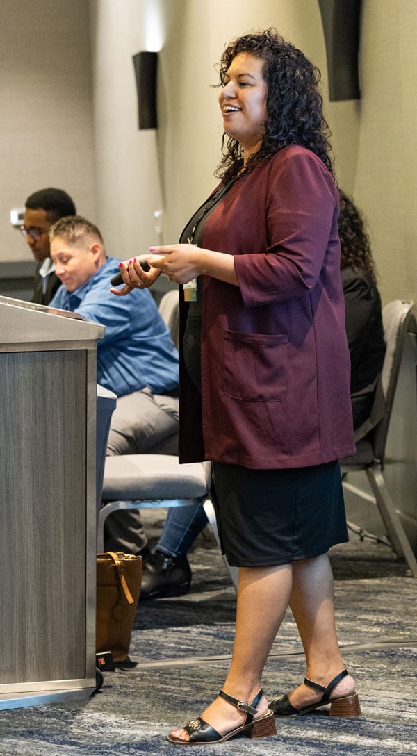 Side-view of a conference presenter speaking to her audience.